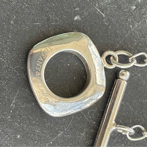 Silver plated black onyx necklace 18” with logo on toggle clasp.